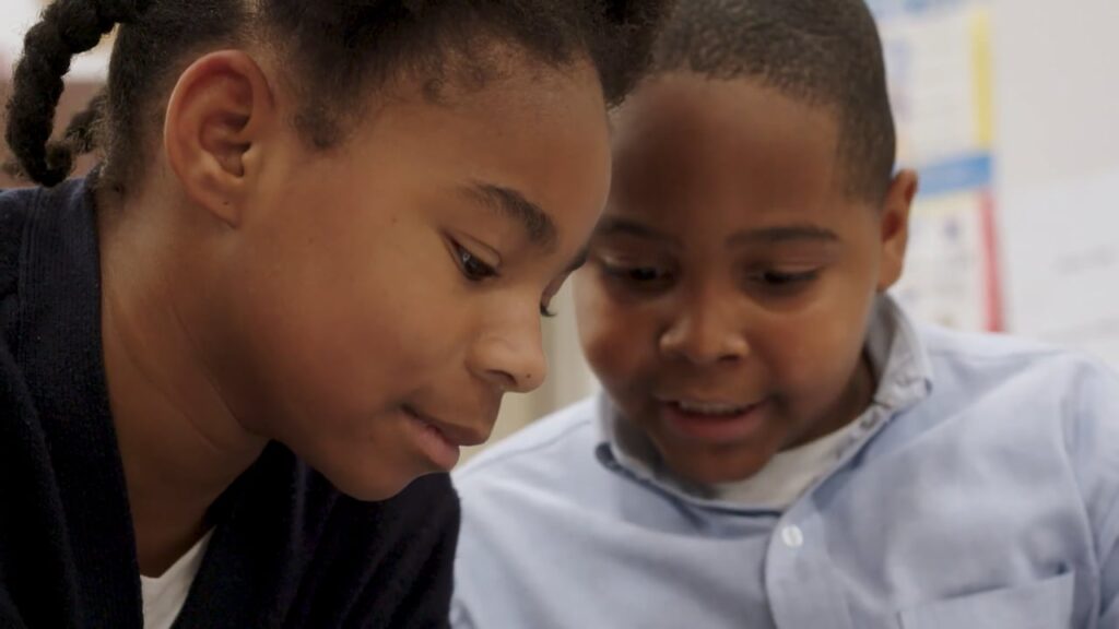 Two children look at school work